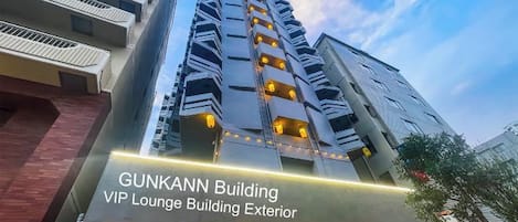 L’extérieur du bâtiment Gunkann se distingue par son architecture moderne, avec de nombreux balcons et une entrée imposante.