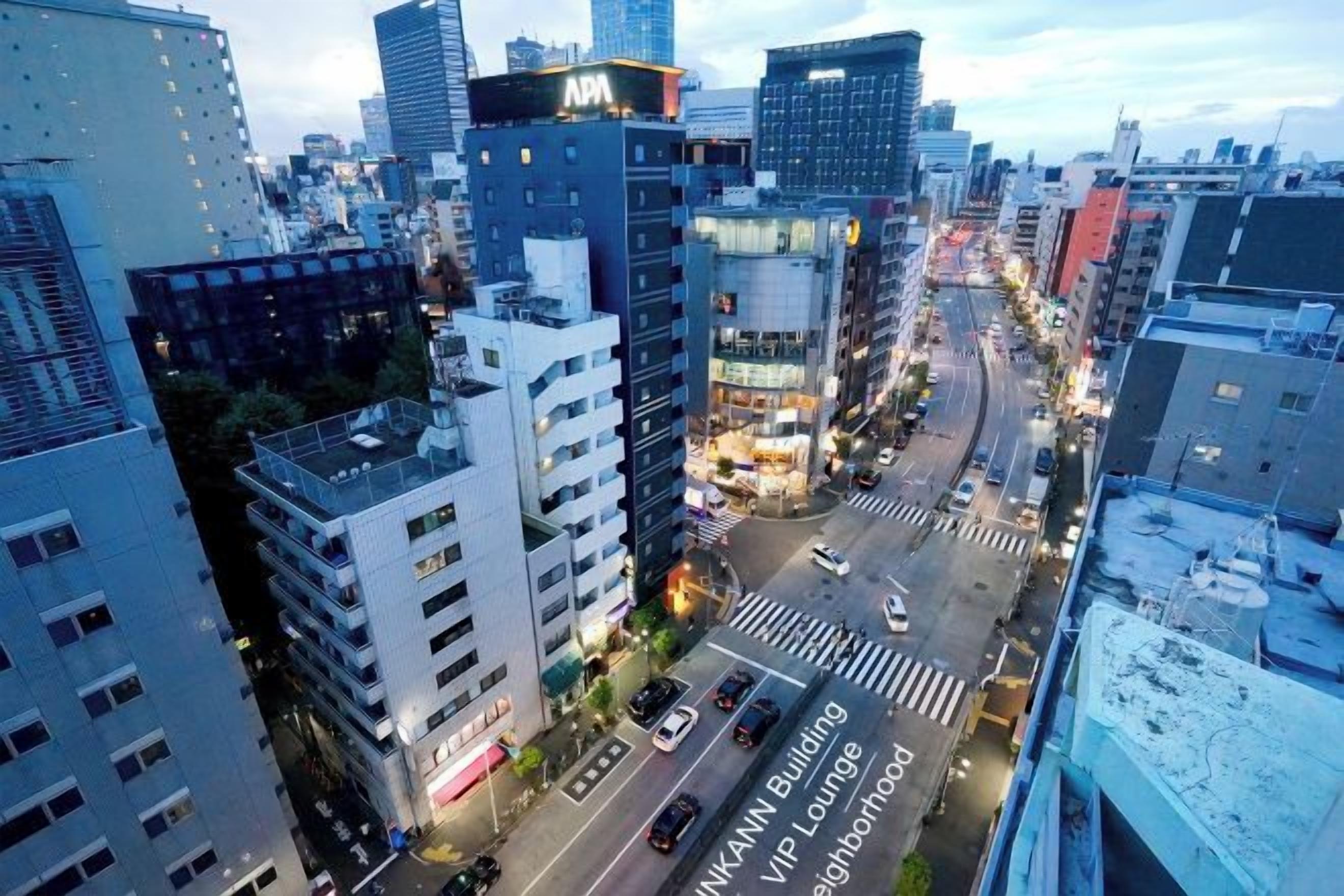 A cityscape with modern buildings, a busy street, and a clear sky.