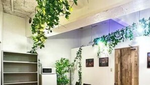 A conference room with a wooden table, black chairs, a whiteboard, and green plants. - 4 min train to Shinjuku ｜ 8 min walk to station ｜Up to 6 guests｜Newly renovated｜loft (Tokyo)
