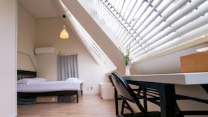 A modern room with a bed, a desk, and a window with blinds. - 4 min train to Shinjuku ｜ 8 min walk to station ｜Up to 6 guests｜Newly renovated｜loft (Tokyo)
