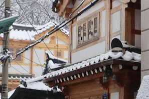 Un edificio tradicional con tejado cubierto de nieve y estructura de madera.