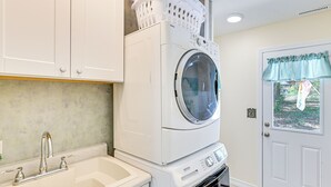 Une buanderie équipée d’un lave-linge, d’un sèche-linge et d’un évier.