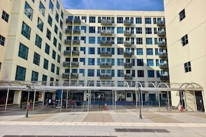 A multi-story building with a covered entrance area, large windows, and balconies.