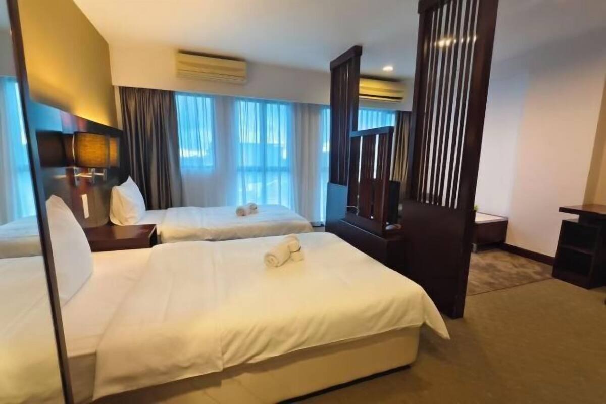Ein Hotelzimmer mit zwei Betten, einem großen Spiegel und einem Schreibtisch.