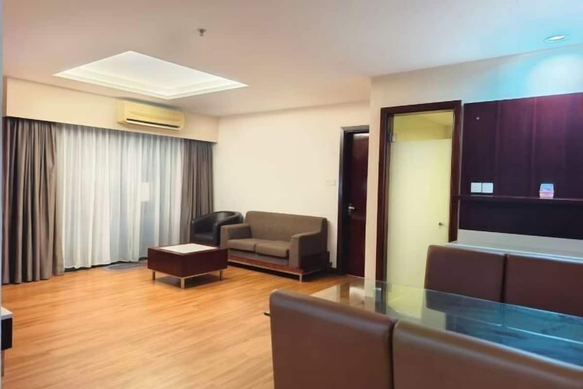 A modern living room with a sofa, a coffee table, and a glass-top dining table.