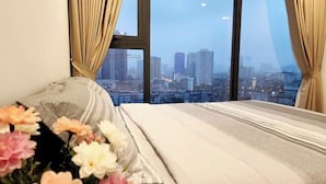 Ein Hotelzimmer mit einem großen Fenster und Blick auf die Stadt.