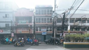 A street view with a crosswalk, buildings, and various signs including 'SUPER HARDWARE'. - RedDoorz @ MUBG Apartelle near Baclaran Church (Paranaque)