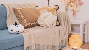 A cozy living room with a blue sofa, a beige throw blanket, a white pumpkin decoration, and a woven floor lamp. - New Garfieldhome Shinjuku (Tokyo)
