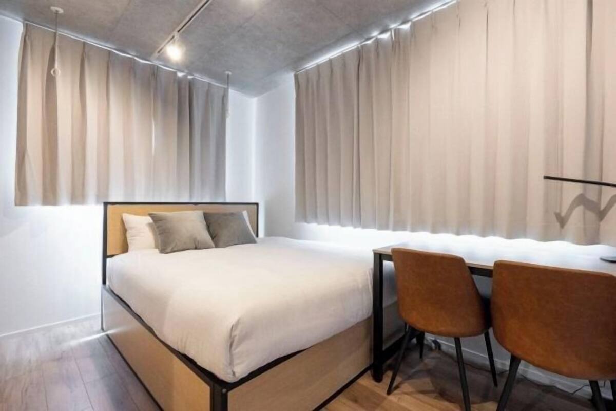 Una camera da letto moderna con un letto, una scrivania e due sedie.