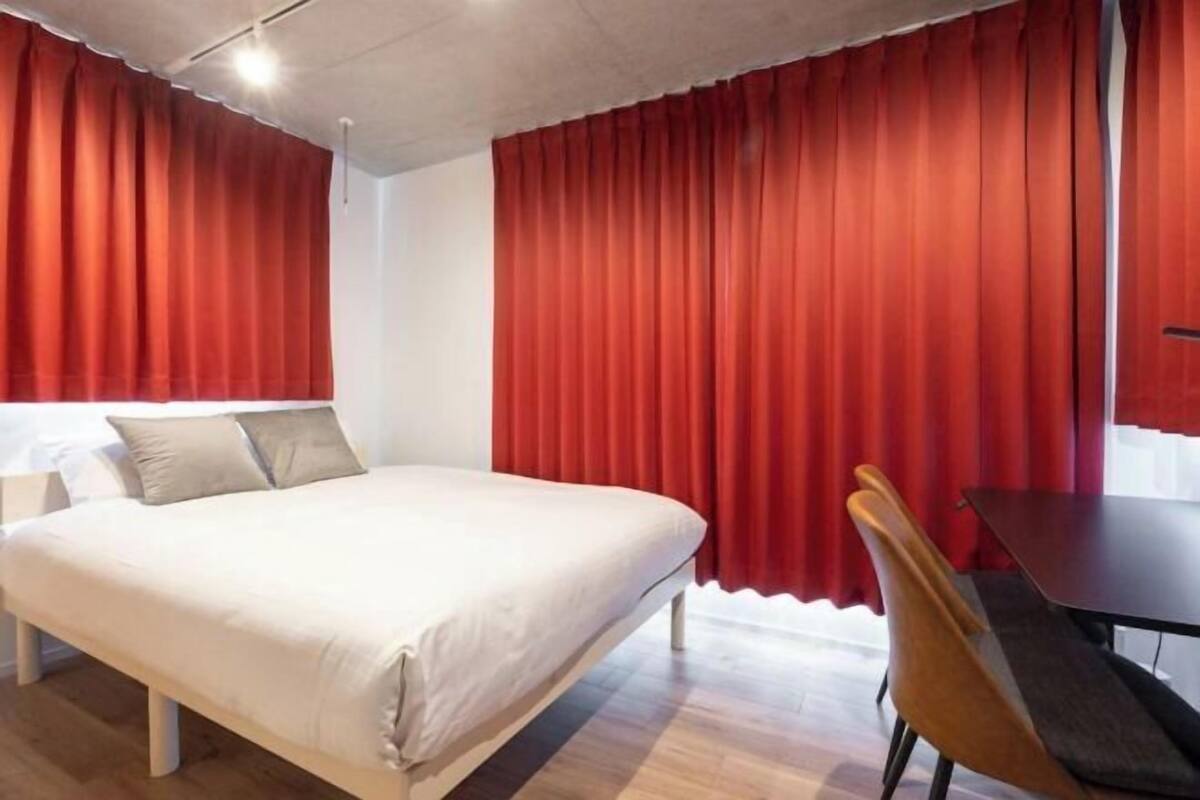 Una camera d'albergo con un letto, una scrivania e una sedia.