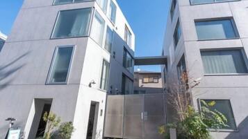 Un edificio moderno con un patio central, ventanas amplias y una verja de metal.
