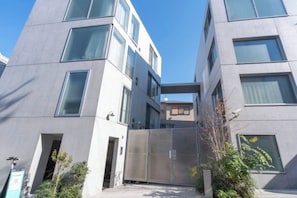A modern building with a central courtyard, large windows, and a metal gate. - LEGALAND Hatagaya ANNEX (Tokyo)