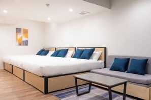 A modern hotel room with a large bed, a sofa, a small table, and a painting on the wall. - LEGALAND Hatagaya ANNEX (Tokyo)