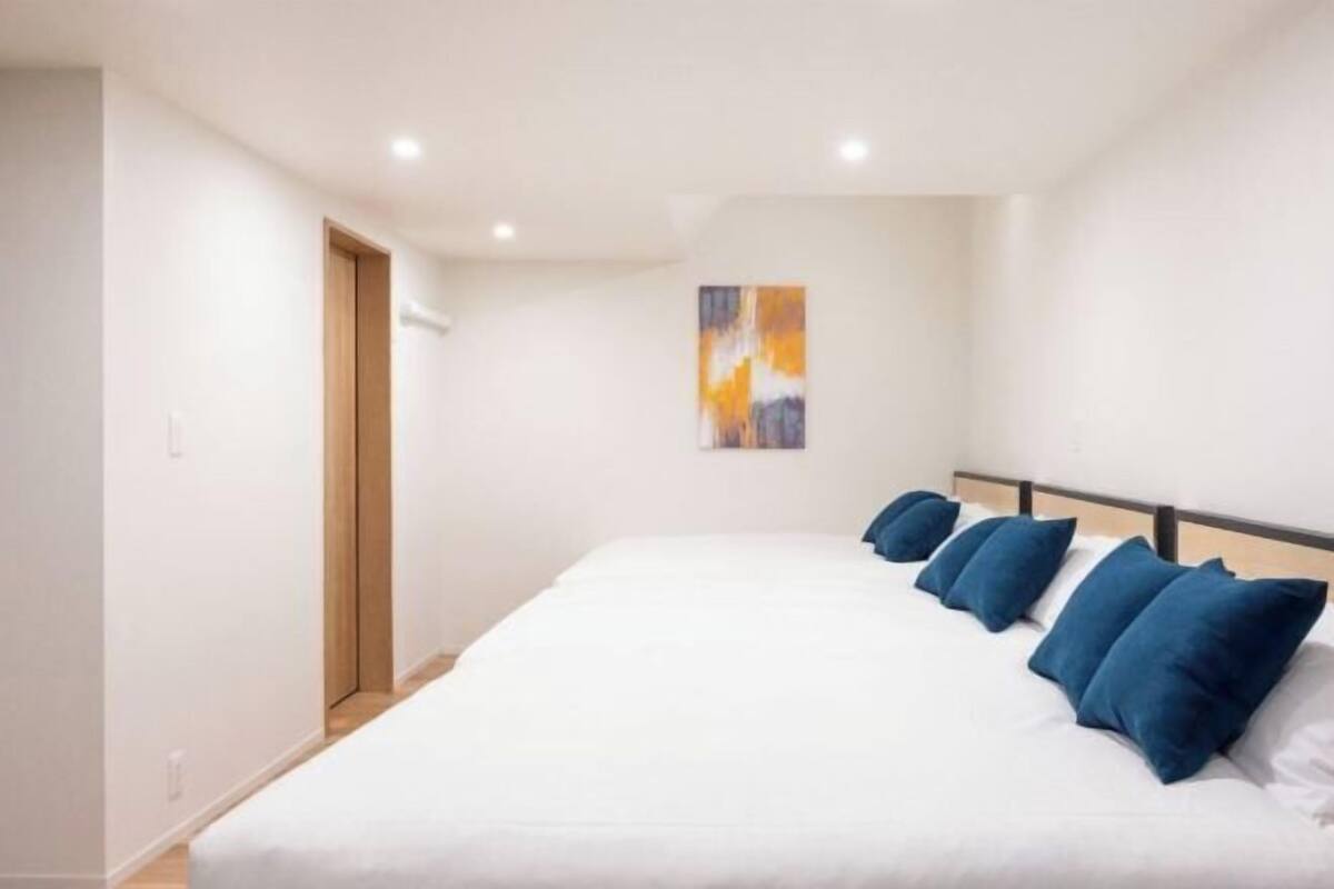 Una camera da letto con un letto grande, una porta in legno e un quadro appeso al muro.