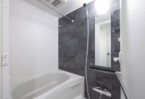 A modern bathroom with a bathtub, a shower, and a mirror. - LEGALAND Hatagaya ANNEX (Tokyo)