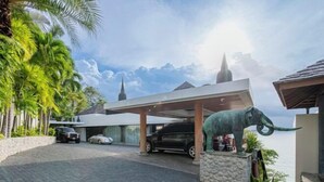 Un bâtiment moderne doté d’un parking couvert, d’une statue d’éléphant et offrant une vue sur la mer.