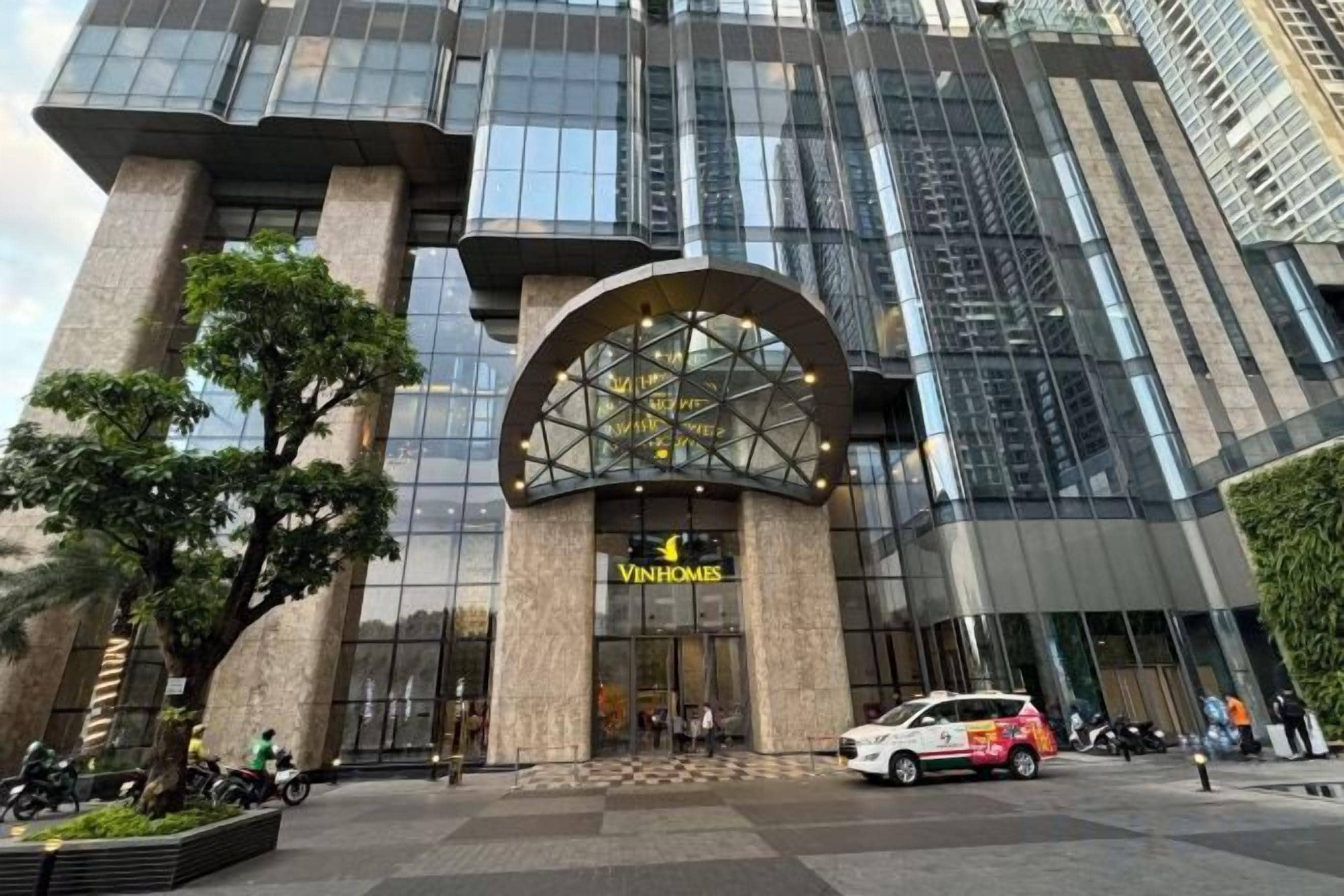 A modern building with a large glass facade and a prominent arch entrance.