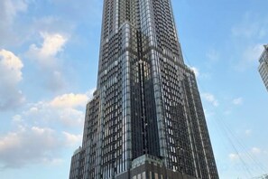 A tall, modern skyscraper with a glass facade and a grid-like pattern of windows. - THE LANDMARK 81 LUXURY ART CONDOTEL (Ho Chi Minh City)
