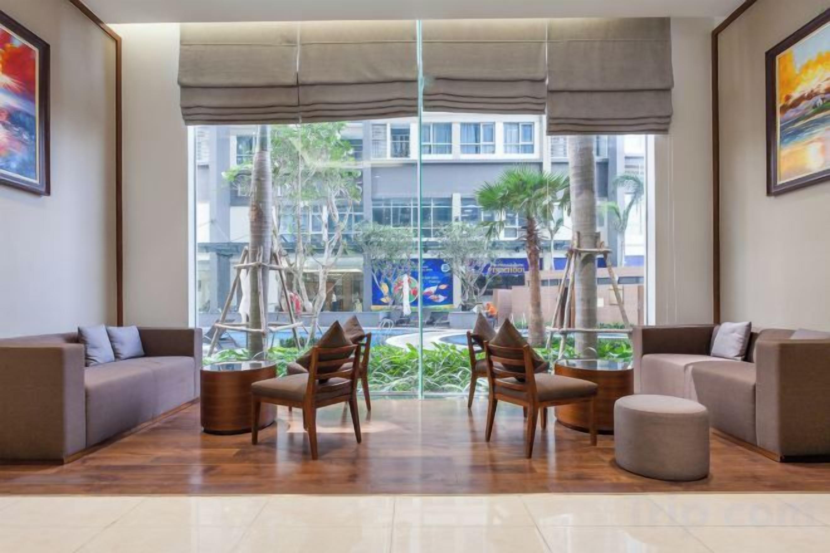 Un vestíbulo moderno con zona de estar, grandes ventanales y vistas al exterior.