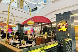 Un restaurant avec un parasol rouge et une enseigne indiquant « Chilli Thai ».