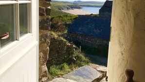 Un bâtiment en pierre offrant une vue sur une plage et l’océan.