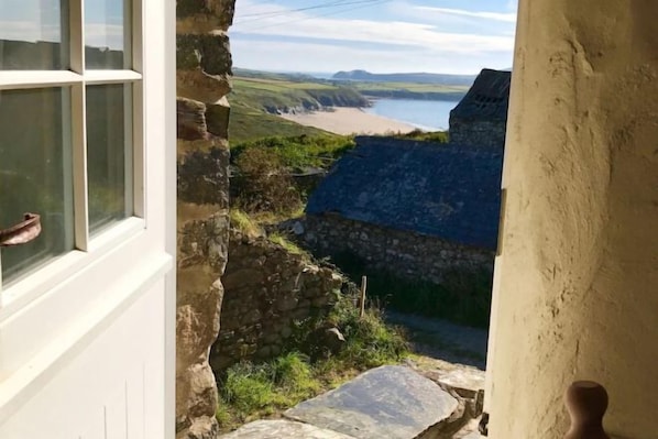 A stone building with a view of a beach and water. - Tan y Garn - 2 Bedroom Cottage - Whitesands (Saint David's and the Cathedral Close)