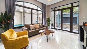 A modern living room with a sofa, yellow armchair, and a coffee table. - KN3 Holiday Villa (Ho Chi Minh City)