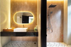 Une salle de bain avec un lavabo, un miroir et une douche.
