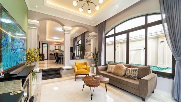 A spacious living room with a sofa, coffee table, and a television. - KN3 Holiday Villa (Ho Chi Minh City)