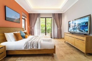 Ein modernes Hotelzimmer mit einem großen Bett, einem Fernseher und einem Holzkasten.