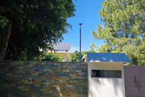 A stone wall, a small building with a blue roof, and a tree. - RU YI HOTEL(SMC-PRIVATE) LIMITED (Islamabad)