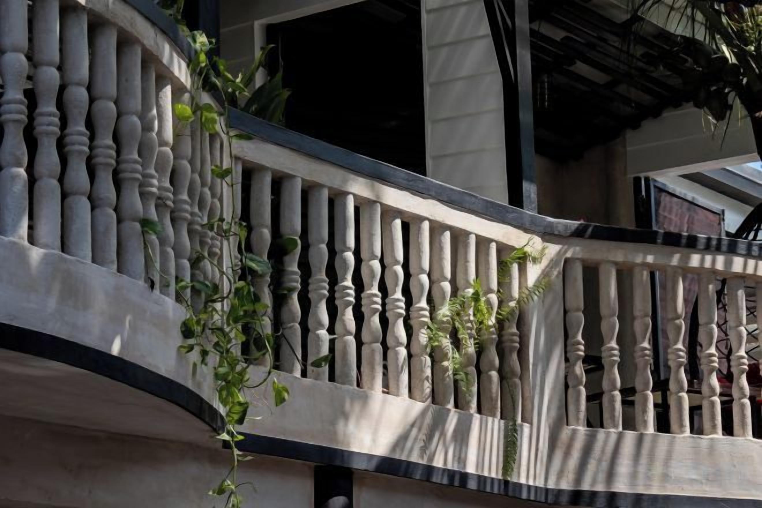 A balcony with balustrades and climbing plants.