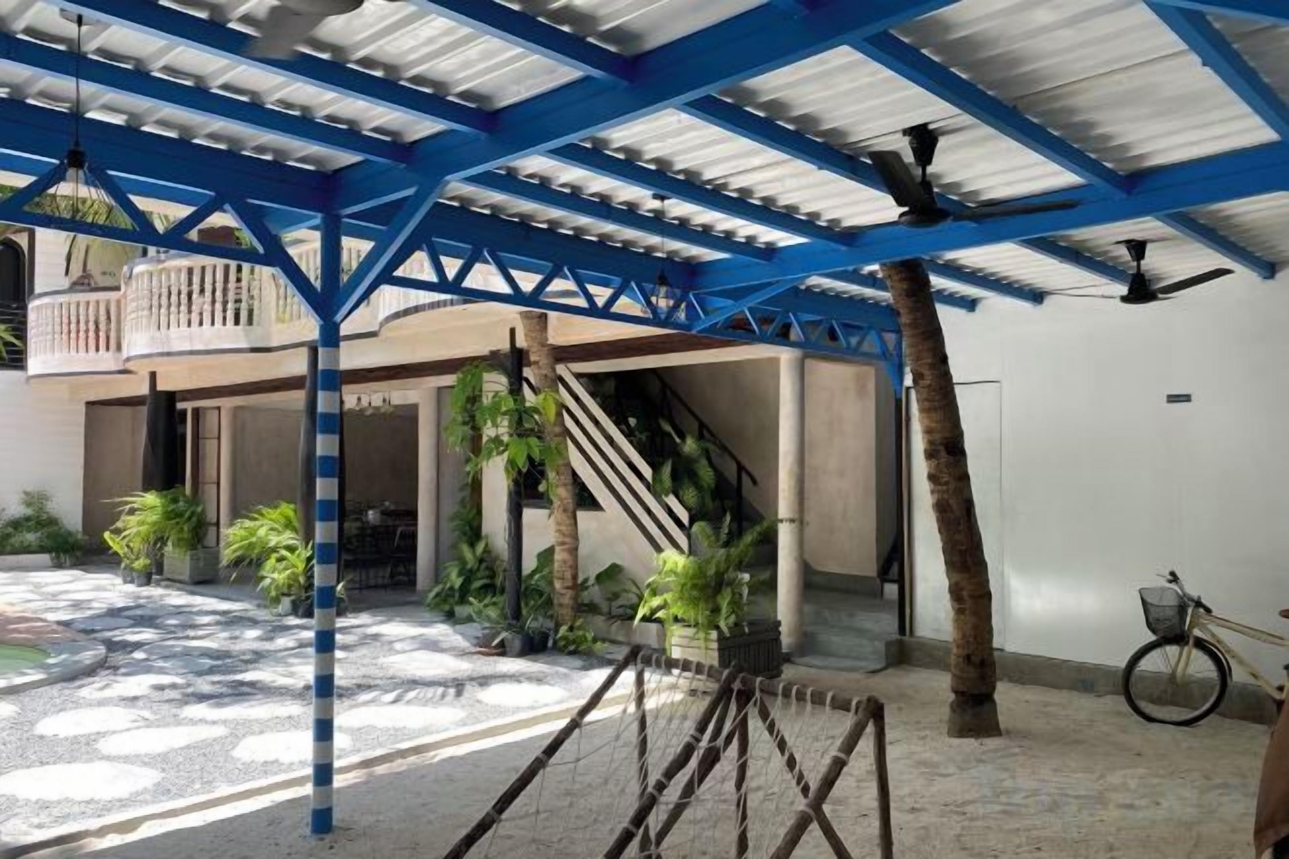 An outdoor covered area with a staircase, potted plants, and a bicycle.