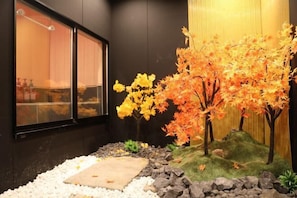 A room with a window, a small indoor garden with rocks and a mossy area, and a wall-mounted shelf. - Kin・ Tengachaya8-14 (Osaka)