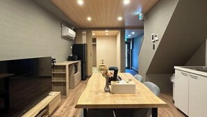A modern kitchen with a wooden countertop, a built-in oven, and a white sink. - Kin・ Tengachaya8-14 (Osaka)