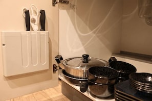 A kitchen with a built-in oven, a pot rack, and a set of knives. - Kin・ Tengachaya8-14 (Osaka)