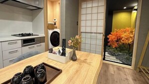 A modern kitchen with a gas stove, a washing machine, and a tray with jars. - Kin・ Tengachaya8-14 (Osaka)