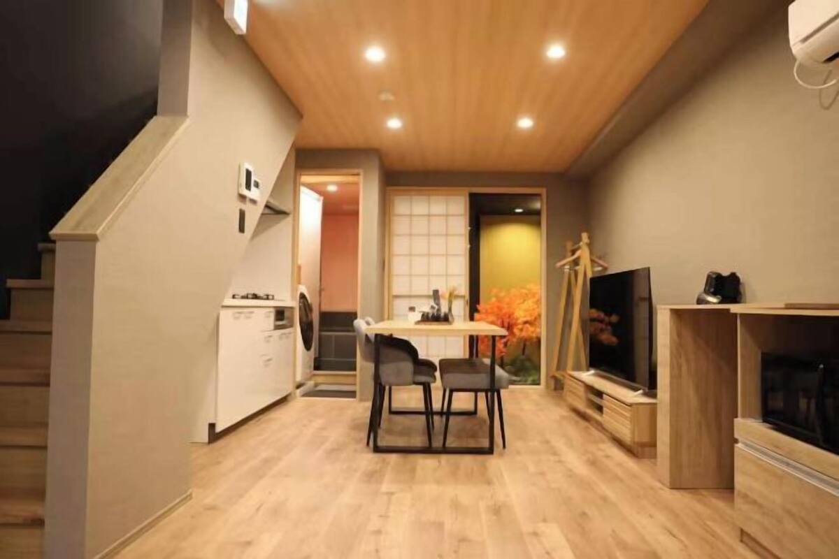 A modern interior with a dining area, kitchen, and entertainment unit.
