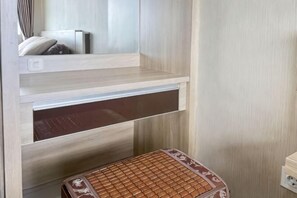 Un baño con tocador de madera, un perchero y un taburete pequeño.