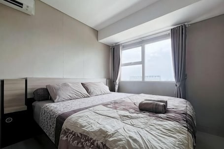 A hotel room with a bed, a window, and a view of the city.. MODERn Trivium Apt 1BR w/ Wi-Fi, Pool & Gym