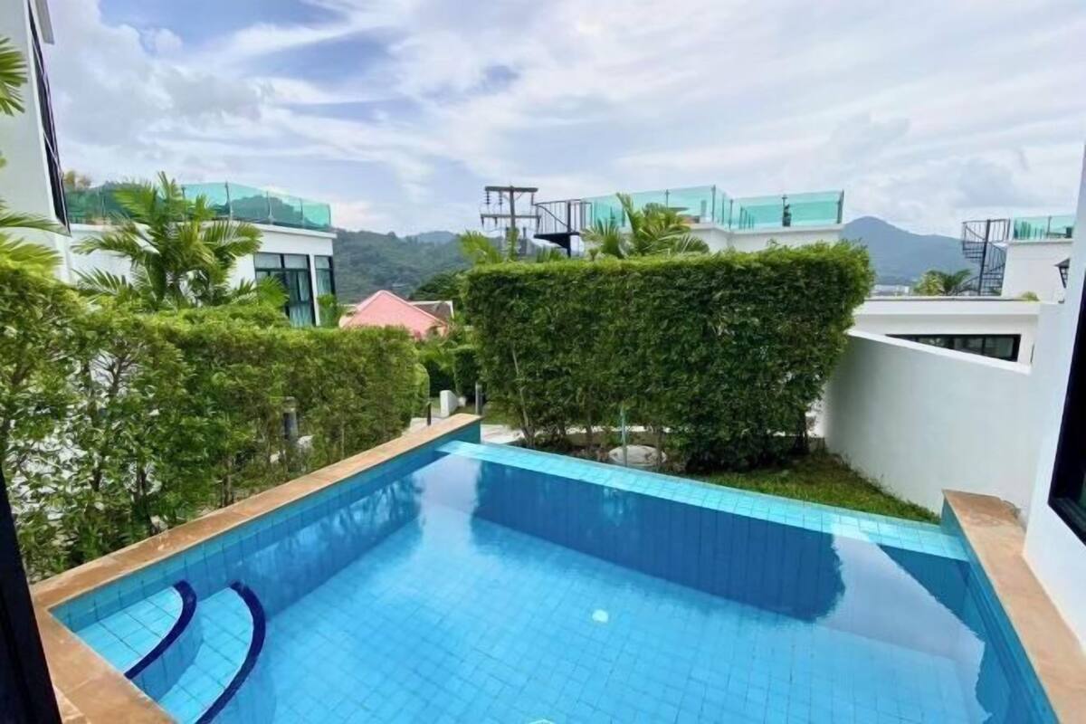 A swimming pool with a view of surrounding buildings and greenery.