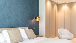 Una camera da letto moderna con un letto, un comodino, una lampada e una sedia.