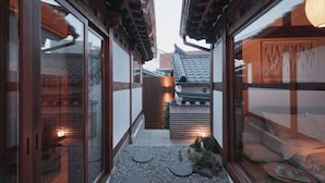 A traditional Japanese-style corridor with sliding doors and a small garden area with stepping stones and a lantern. - [NuileStay] Seoul Gorgeous Hanok - Gyeongbokgung Station(5min) (Seoul)