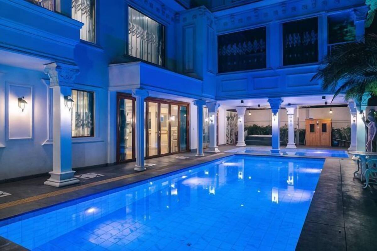 A pool area with columns, a door, and a staircase.