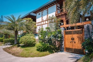 A traditional Japanese-style building with a wooden gate, surrounded by lush greenery and palm trees. - Amazing Pool Villa Pattaya (Pattaya)