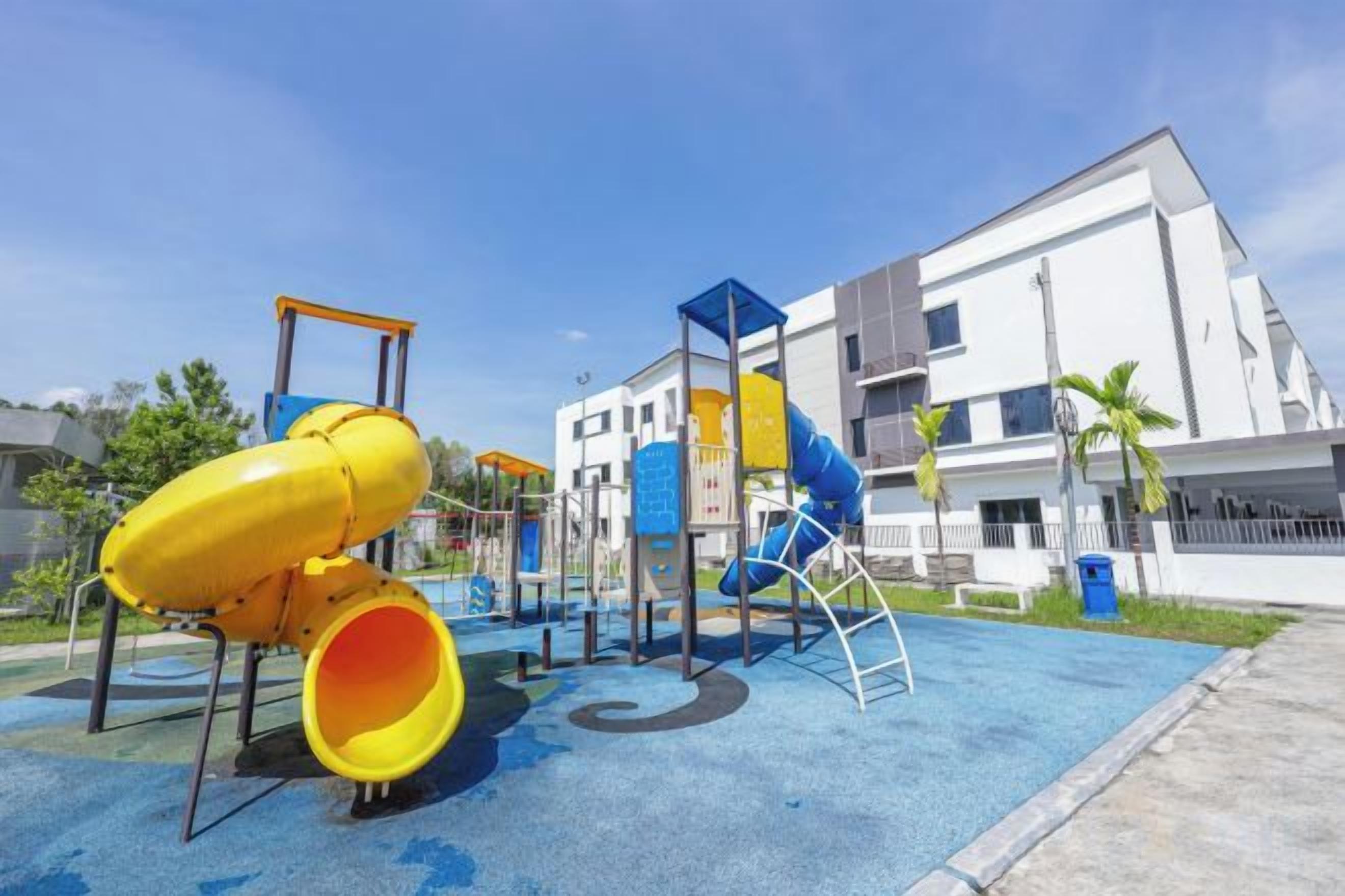 Un parque infantil con toboganes y estructuras para escalar, rodeado por un edificio con balcones.