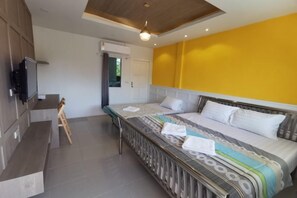 Un dormitorio con una cama, un televisor y una mesita.