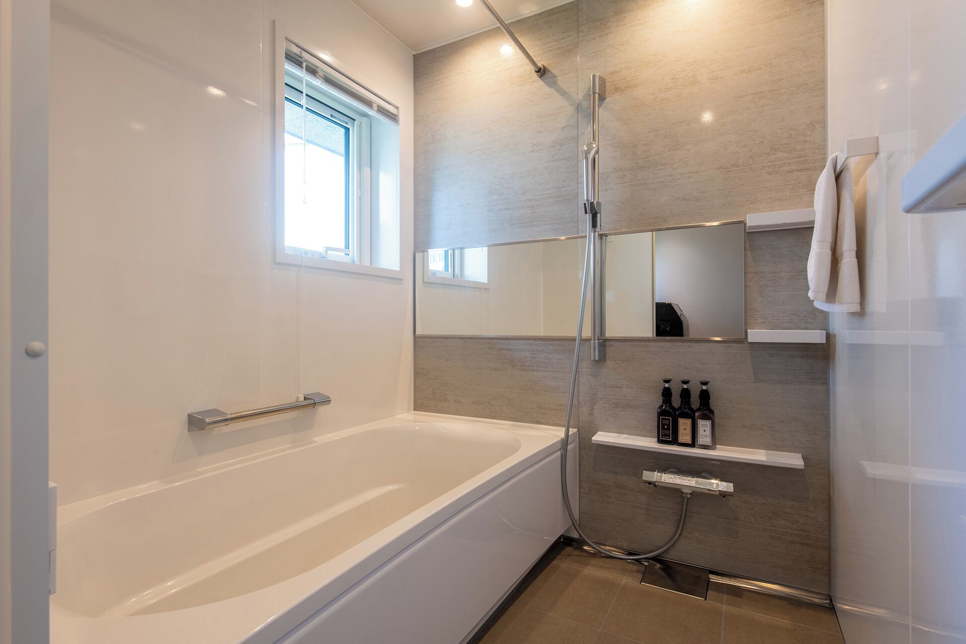 A modern bathroom with a bathtub, a shower, and a vanity with toiletries.