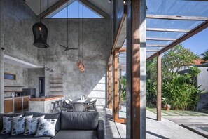 A modern interior with a dining area, kitchen, and large windows.