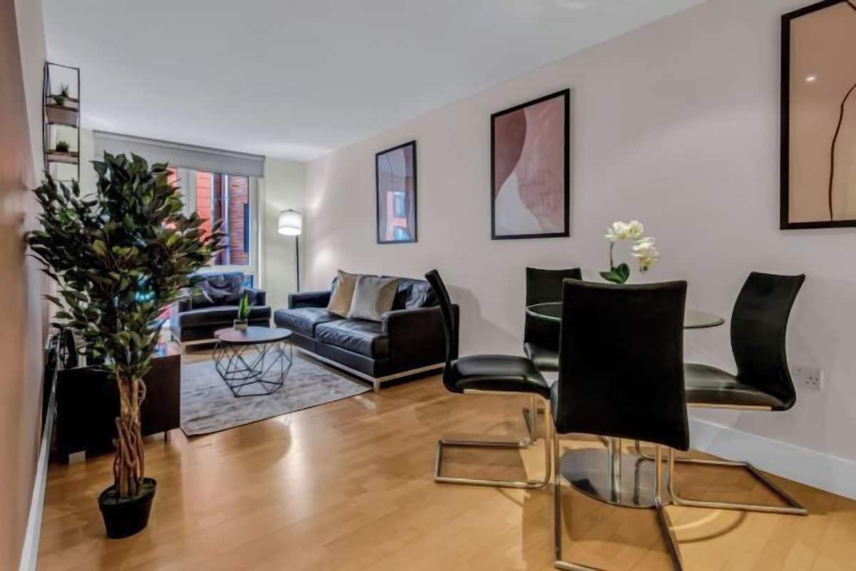 Un salon moderne avec un canapé, des fauteuils, une table basse et une plante en pot.